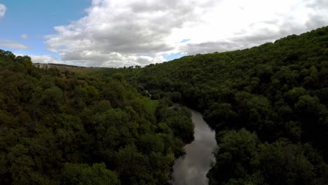 vista aérea de un río que fluye a través de un bosque de distrito pico, comúnmente utilizado por ciclistas, excursionistas, popular entre turistas y veraneantes, inglaterra rural, reino unido