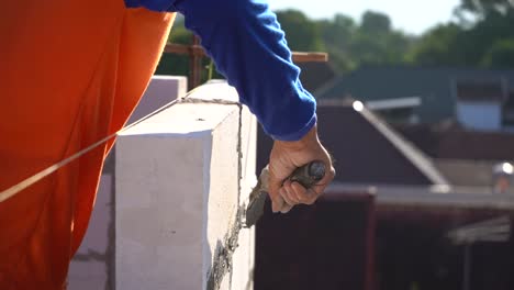 a worker applying cement to a pile of bricks