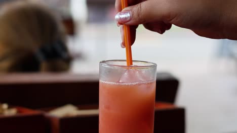 agitar a mano el jugo de fruta con una pajita