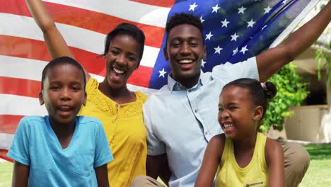 family smiling and posing with the american flag