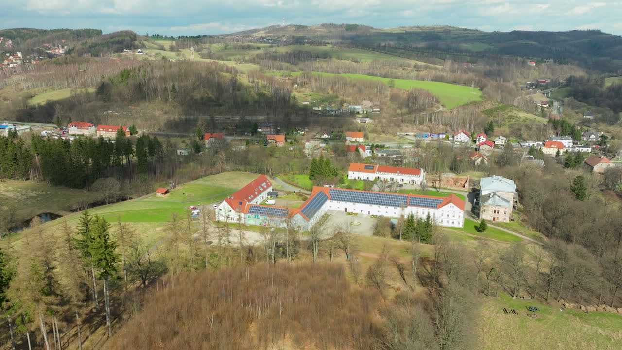 vista aérea del hotel jedlinka y el palacio jedlinka rodeados de un campo boscoso en jedlina-zdroj, polonia