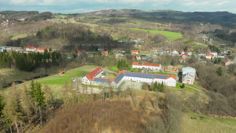 vista aérea del hotel jedlinka y el palacio jedlinka rodeados de un campo boscoso en jedlina-zdroj, polonia