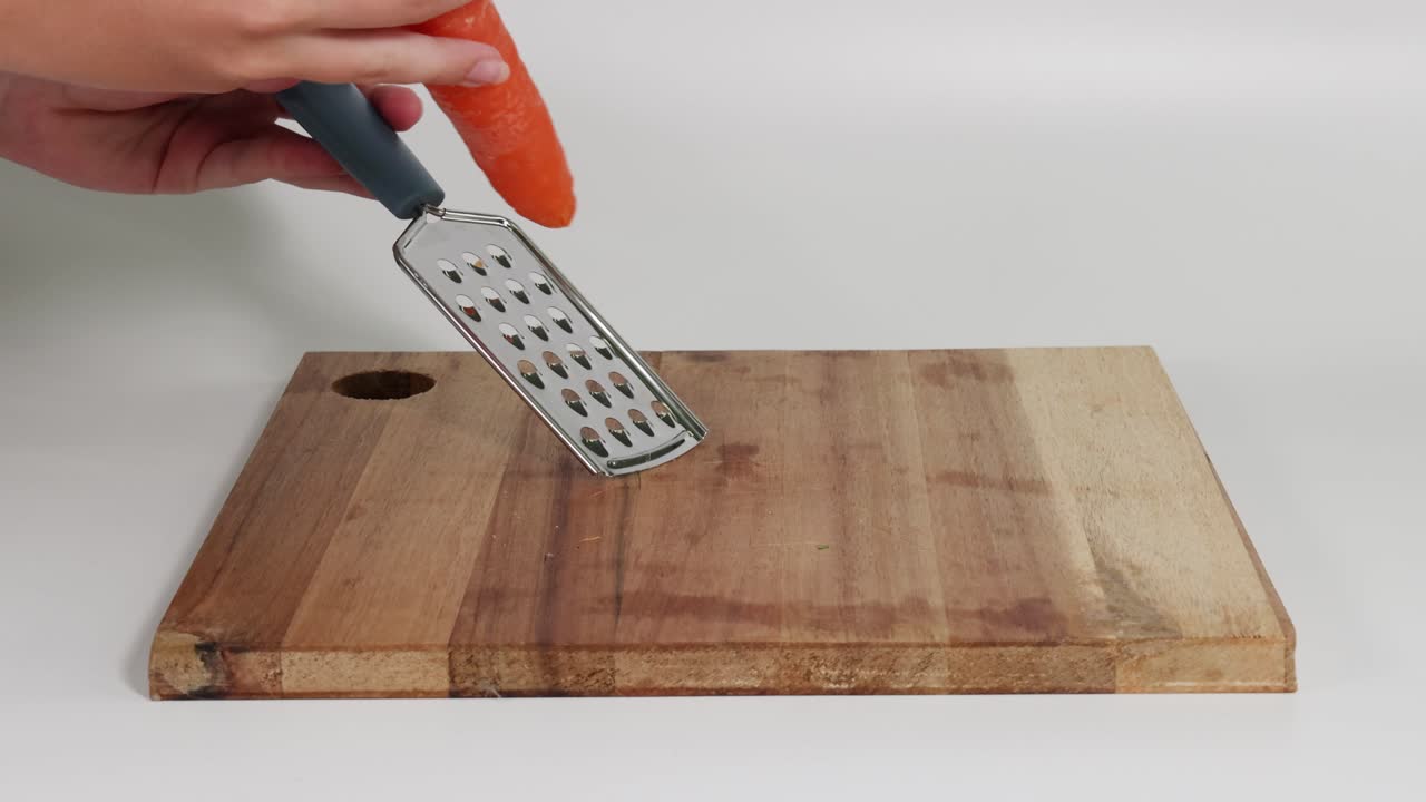 demostración secuencial de raspar una zanahoria en una tabla