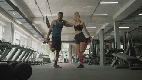 Distant-view-of-caucasian-female-monitor-and-an-athletic-african-american-man-in-the-gym.