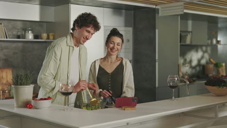 young couple cooking and enjoying wine in a modern kitchen