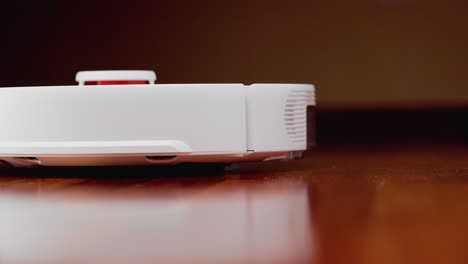 robot aspirador inteligente con lidar en el suelo de madera. robot aspirador realiza la limpieza automática del apartamento. 4k cámara lenta 100 fps, prores 422, 10 bits
