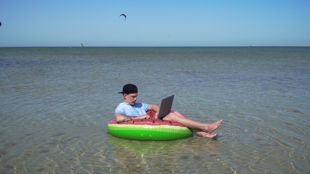A young business person is enthusiastically working behind a laptop swaying on the waves of sea