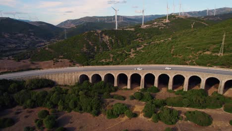 Aerial-view-following-vehicles-driving-the-Tarifa-highway-with-wind-turbines-along-the-Spanish-valley