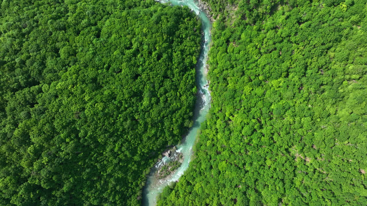 una vista de pájaro de un río de montaña salvaje de color verdoso puro