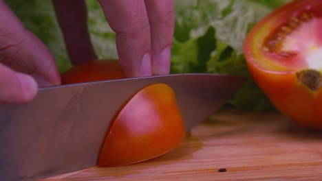 a professional chef slices a juicy red tomato, slow motion close up