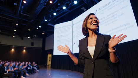 a woman presenting on stage to an audience at a conference