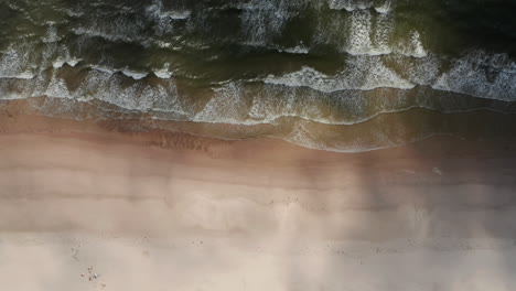 Vogelperspektive-Aus-Der-Luft-Von-Oben-Nach-Unten-Horizontales-Schwenken-Von-Aufnahmen-Von-Wellen,-Die-Einen-Sandstrand-An-Der-Nordseeküste-Waschen.-Dänemark
