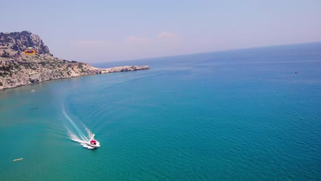 Turistas-Haciendo-Parasailing-En-La-Costa-De-La-Playa-De-Tsambika,-Grecia