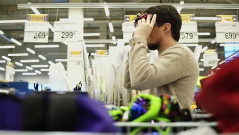 man shopping for winter sports equipment in a store