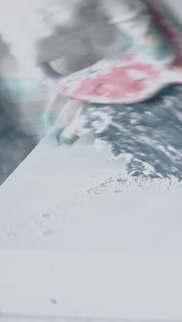 skilled worker in gloves holds big saw and cuts large white gypsum plasterboard professionally close view