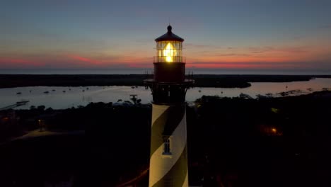 a drone circles am illuminated lighthouse