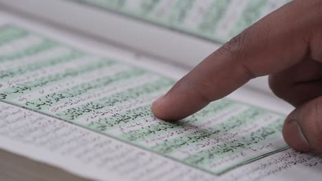 Closeup of muslim man reading Quran book