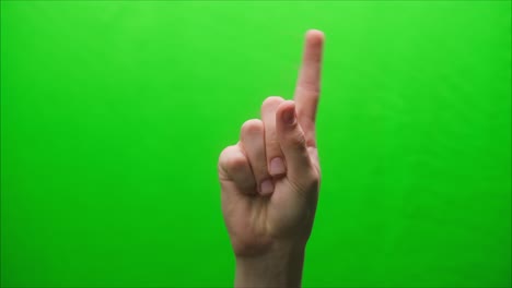 primer plano de un gesto de la mano sobre un fondo verde, disparar un gesto en el estudio, agitar el dedo a alguien, levantar un dedo amenazante