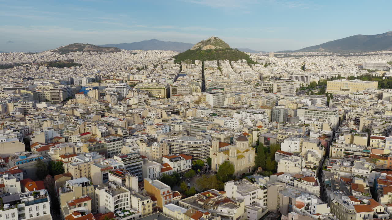 Vasta distesa urbana di Atene con la Cattedrale Metropolitana, l'edificio del Parlamento greco in basso, il Monte Licabetto sullo sfondo, ampia ripresa aerea