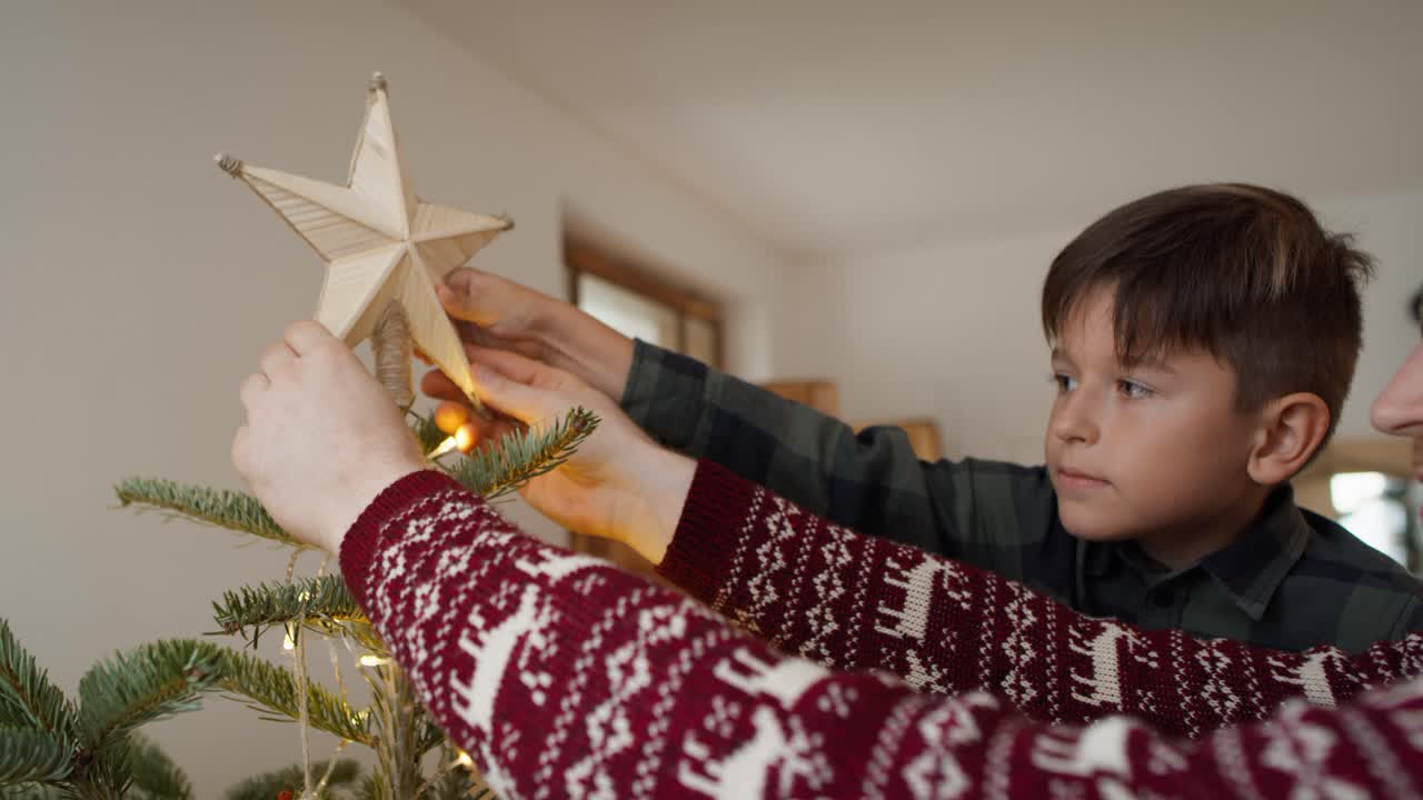 padre e hijo decorando el árbol de navidad