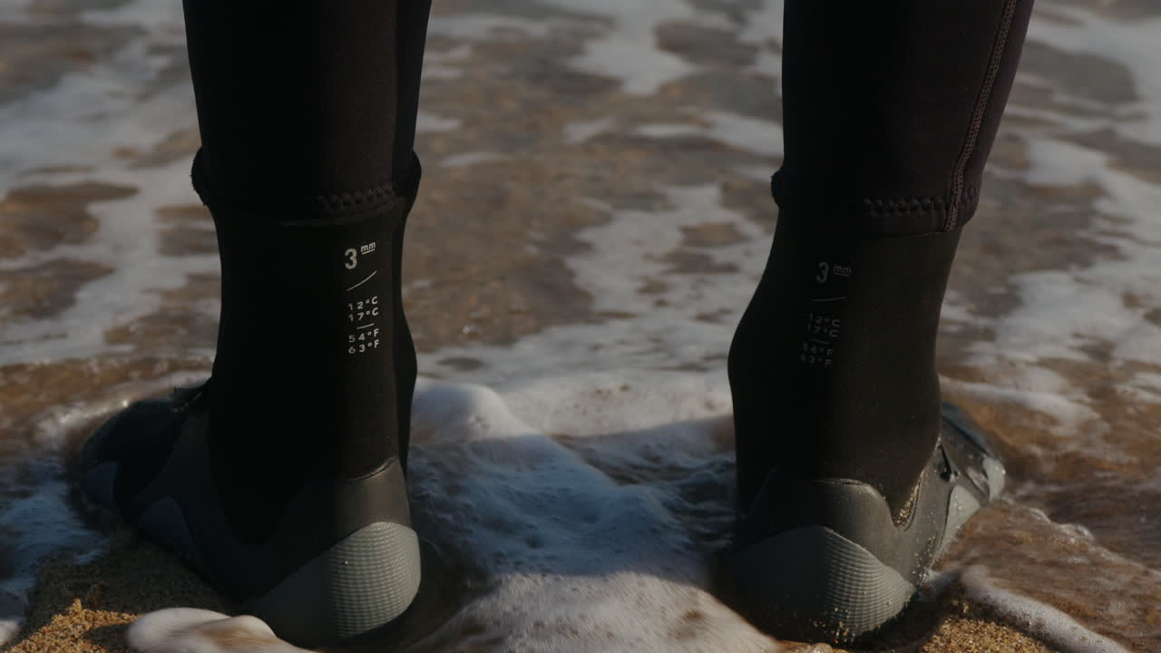 Surfer man walking to the beach at sunset preparing for surfing training and search for waves in Barcelona, spain, water, ocean exercise in sea with board, athletic male holiday or travel in vacation