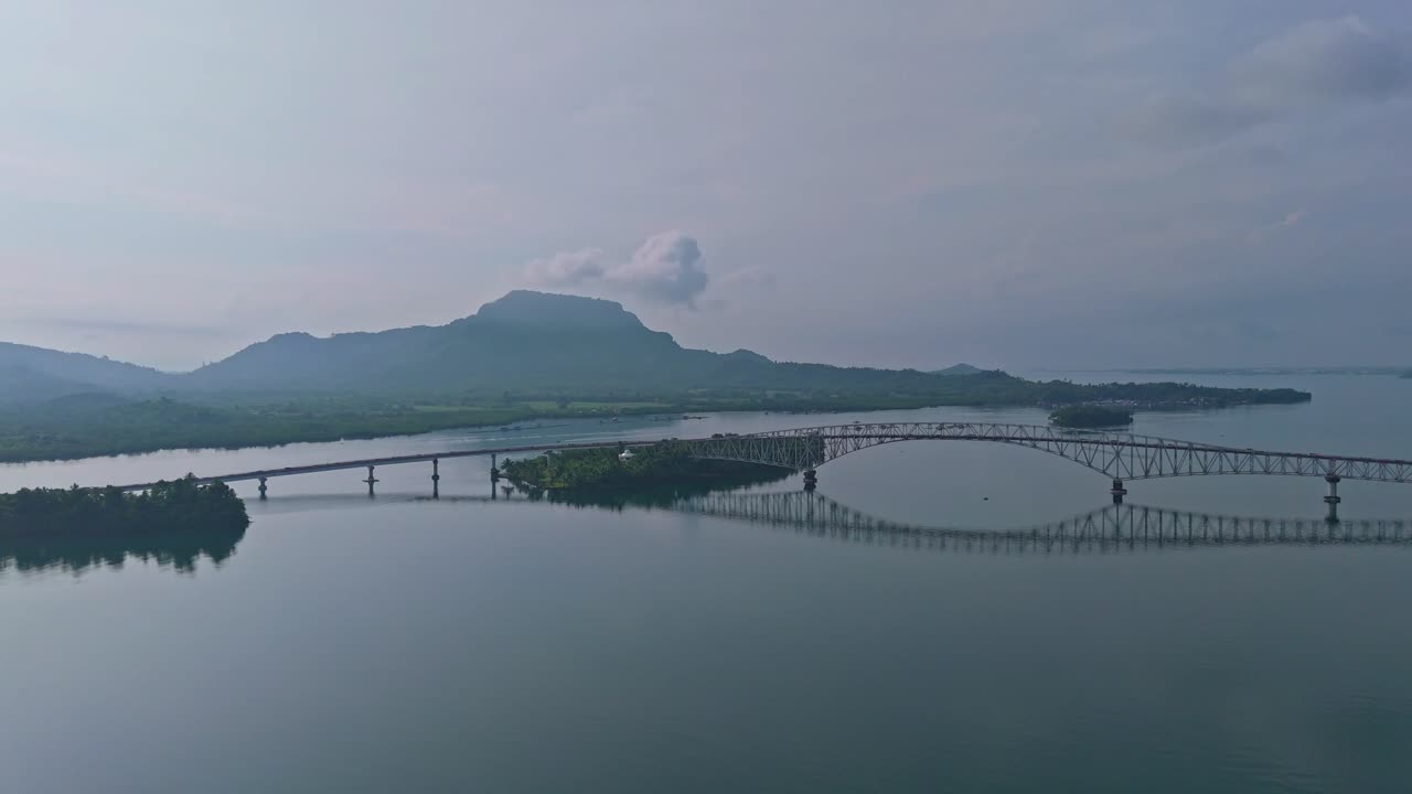 Stunning view of San Juanico Bridge in Tacloban, with misty hills and glassy waters below
