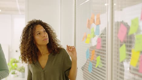 Woman using adhesive notes to present ideas in a coworking