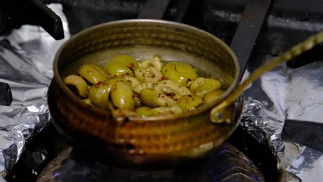 the-cook-is-cooking-oil-and-olives-in-a-saucepan-on-the-stove