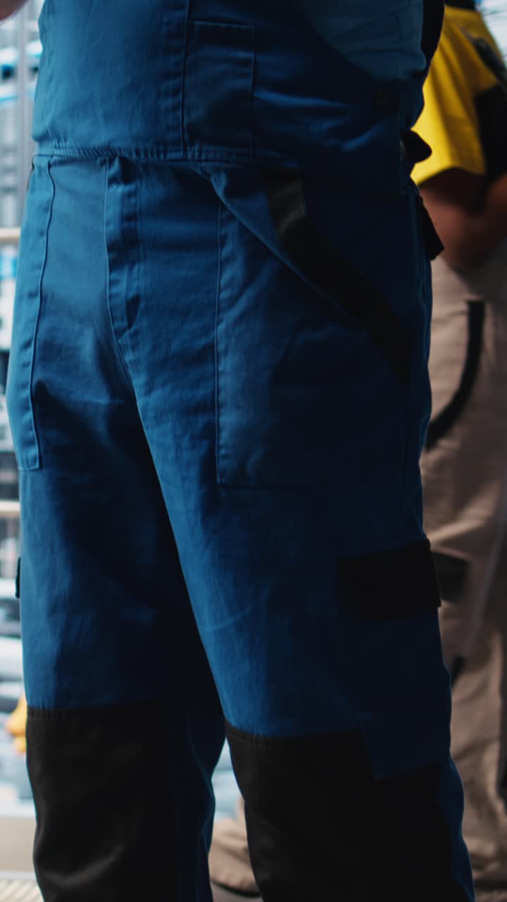 Vertical video Senior engineer using tablet in smart solar panels manufacturing factory