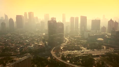 jakarta, indonesia. 14 de septiembre de 2017: imágenes aéreas panorámicas de rascacielos cerca del puente semanggi en el distrito central de negocios de jakarta al anochecer con cielo naranja