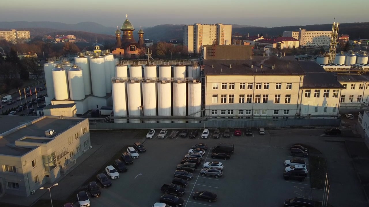 Vista aerea di un drone che sorvola il birrificio, diverse file di serbatoi