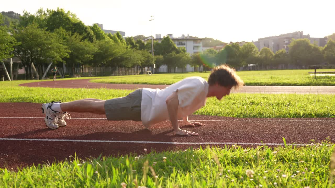 Uomo che fa flessioni su una pista nel parco