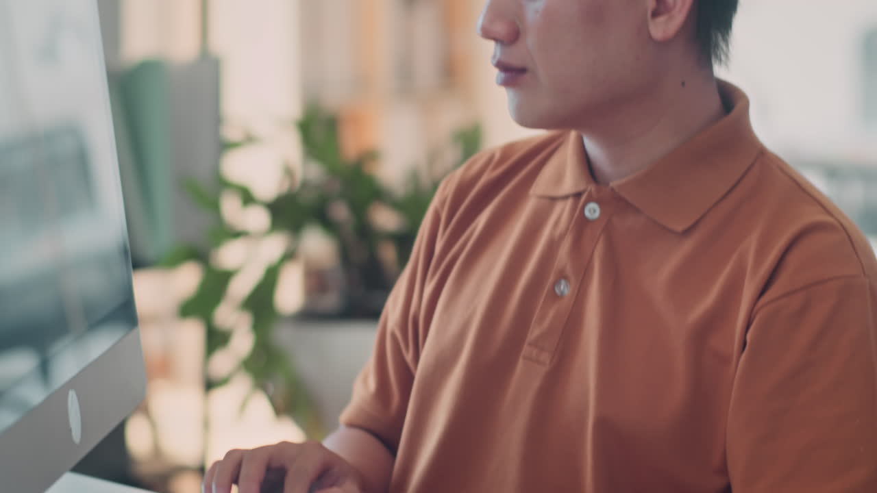 Young Serious Software Engineer Working on Computer