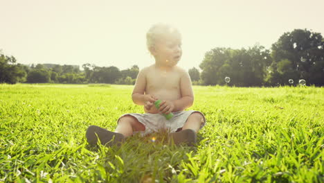 Baby-boy-blowing-soap-bubbles-outdoors