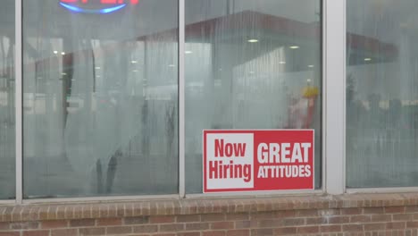 now hiring great attitudes bright red and white sign in window of car wash with condensation and dew on glass, neon open sign, gas station in glass reflection in cinema 4k 30fps slowed from 60fps