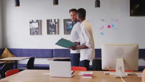 Happy-diverse-business-people-discussing-work-during-meeting-at-office