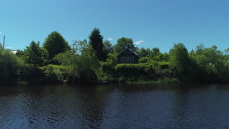 rustic wooden house by a river on a sunny day