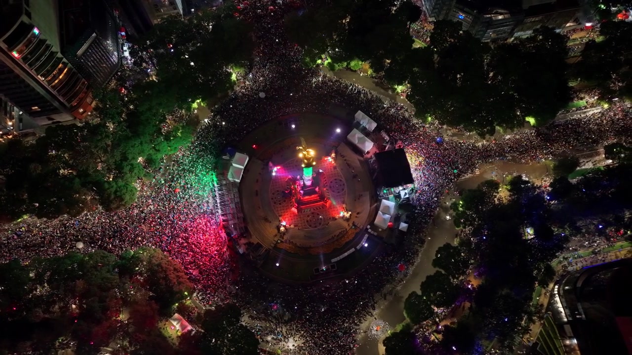 Una vista a volo d'uccello del viale Reforma pieno di persone che festeggiano la vittoria del Messico di notte.