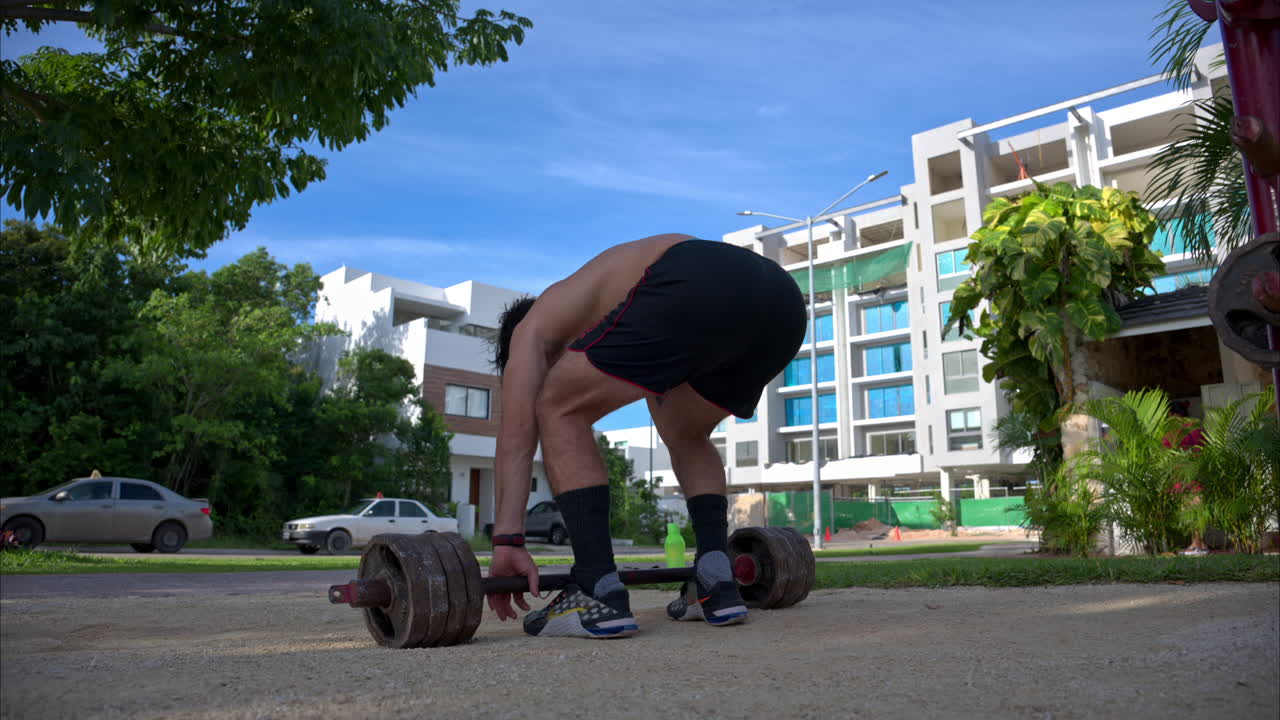 은 아침에 셔츠를 벗고 공원에서 운동하는 라틴인 남자의 느린 동작
