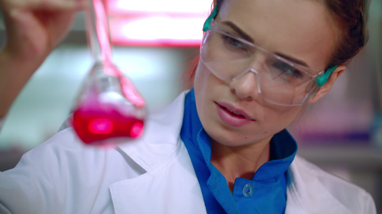 mujer científica trabajando con líquido en un laboratorio de ciencias. primer plano de la mujer científica