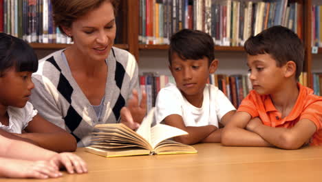 cute pupils with teacher in library