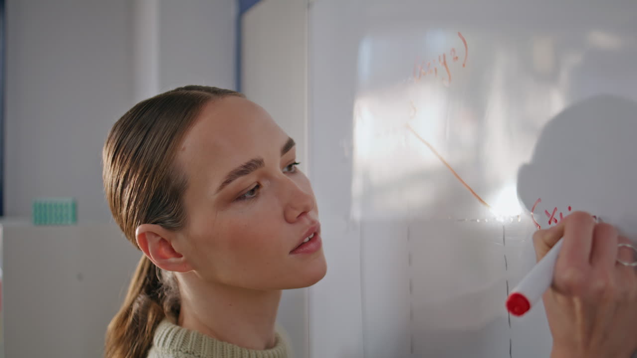 Focused educator solving equation whiteboard closeup. Teacher drawing diagrams