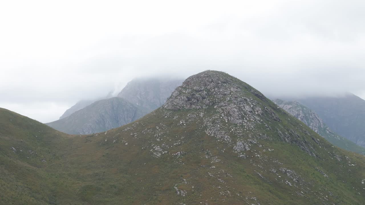 fotografía aérea de una montaña en el paso de outeniqua, cabo occidental, sudáfrica, con los picos en el fondo envueltos en una gruesa capa de nubes bajas.