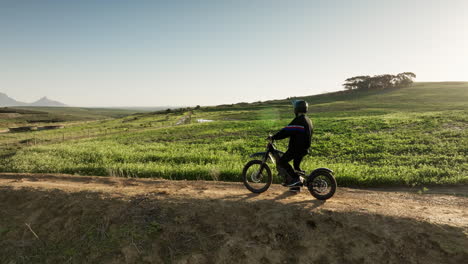 person riding a dirt bike on a trail with a mountain in the background