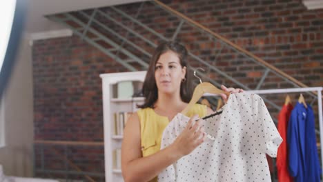 mujer vlogger caucásica haciendo un video de moda en casa