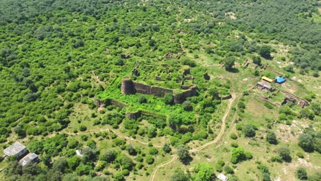 Aerial-drone-shot-of-an-Ancient-fort-or-castle-abandoned-and-covered-with-thick-green-forest-in-Gwalior-Madhya-Pradesh-India