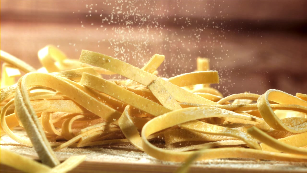 Primo piano di tagliatelle fresche con farina che cade