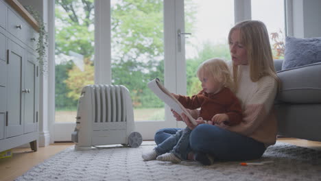 Mother-And-Son-With-Plug-In-Radiator-Drawing-Picture-At-Home-During-Cost-Of-Living-Energy-Crisis