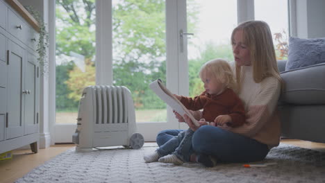 Mutter-Und-Sohn-Mit-Angeschlossenem-Heizkörper-Zeichnen-Ein-Bild-Zu-Hause-Während-Der-Lebenshaltungskosten-Energiekrise