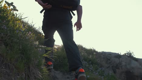 young man enters frame running up hill at golden hour